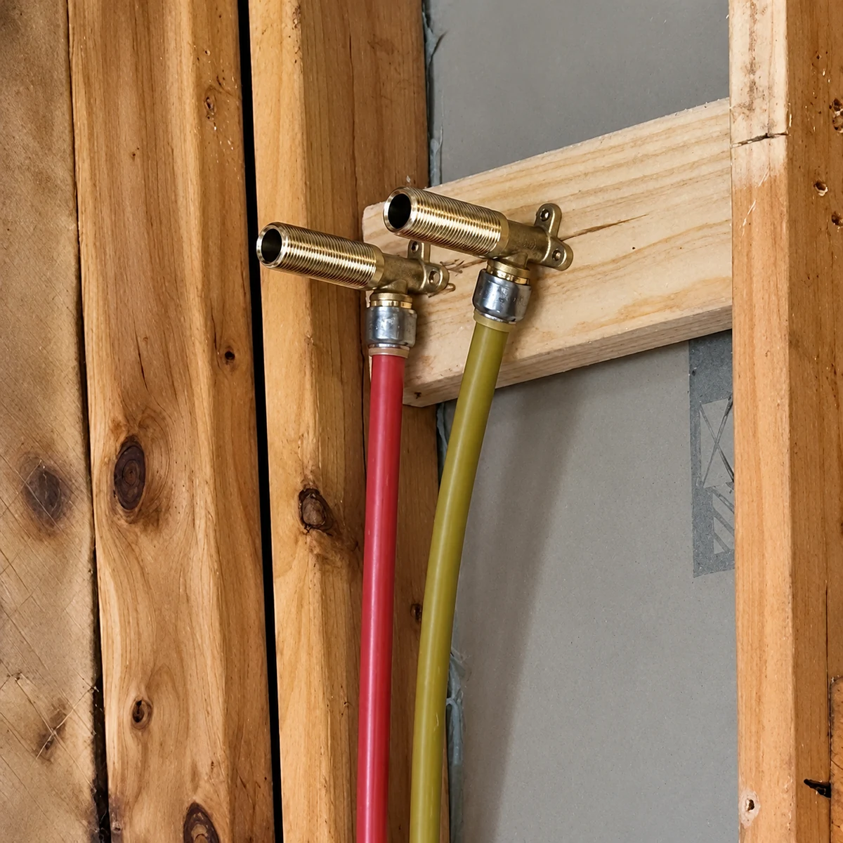 Shower plumbing connections with two separate brass wall fittings on hot and cold supply pipes, ready for mini stops